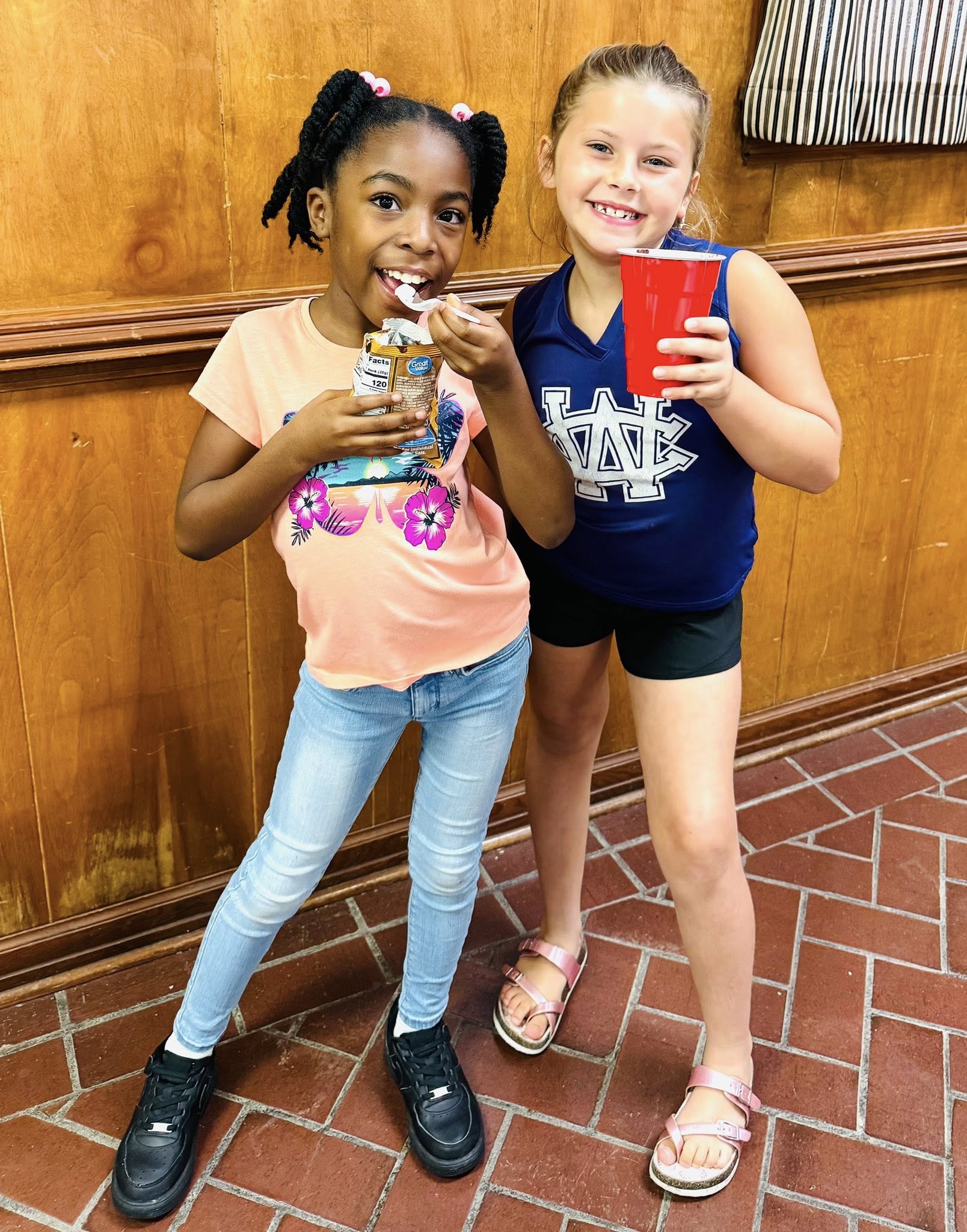 Two little girls posing for a picture.